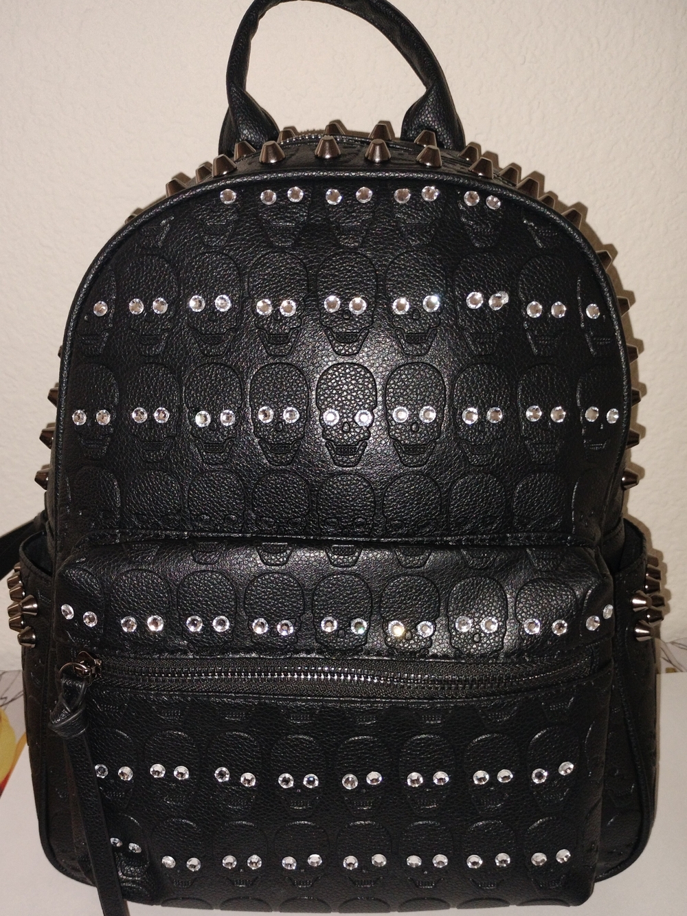 Black Studded Skull Backpack -with black and gold necklace withearrings andnails